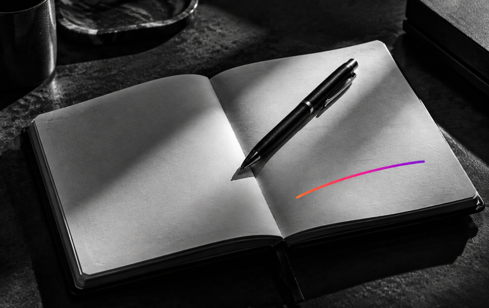 Carnet ouvert et stylo sur un bureau sombre