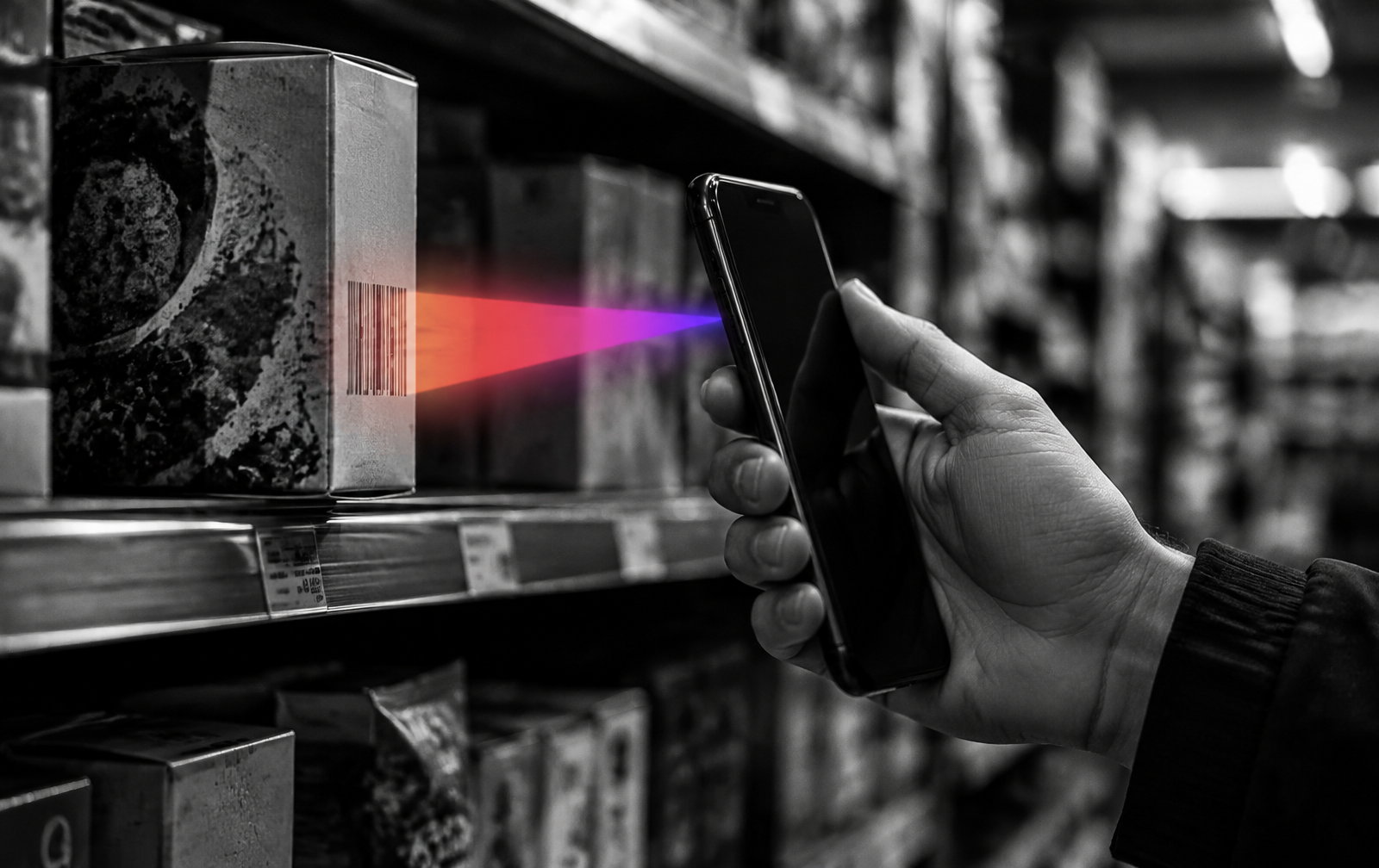Main tenant un smartphone qui scanne un produit en rayon